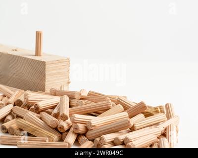 Pila di spine di centraggio scanalate in legno con pannello di legno isolato su sfondo bianco Foto Stock