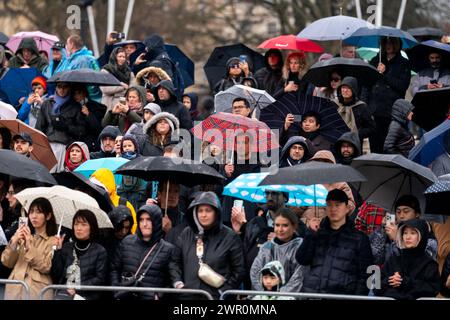 Membri del rifugio pubblico dalla pioggia sul Queen Victoria Memorial a Buckingham Palace, Londra. Data foto: Lunedì 18 dicembre 2023. Foto Stock