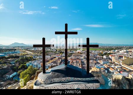 Vista aerea del paesaggio cittadino di Rojales con Monte Calvario e tre croci contro il cielo blu. Rojales, città, Spagna Foto Stock