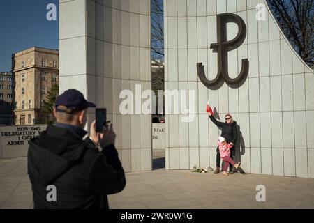 Una donna e un bambino si fanno fotografare sotto un segno dell'esercito della resistenza polacca (Kotwica) vicino al parlamento (Sejm) dopo una manifestazione contro la guerra del 09 Foto Stock