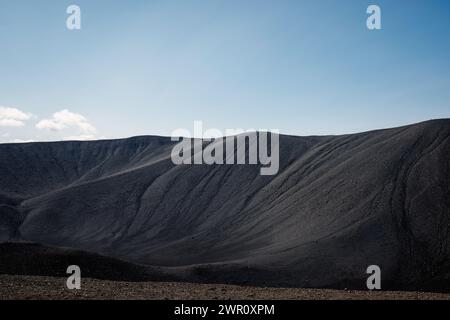 Superficie di sabbia vulcanica nera sul bordo del cratere, vista aerea ravvicinata. Texture, sfondo, concetti astratti. Foto Stock