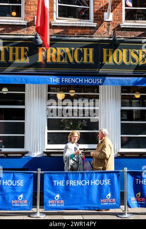 Soho, Londra, Regno Unito, 8 marzo 2024, The French House Bar and Restaurant Dean Street Soho due persone che bevono all'aperto al sole Foto Stock