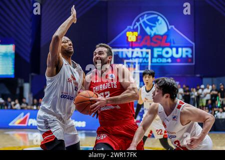 (240310) -- CEBU, 10 marzo 2024 (Xinhua) -- John Mooney (C) dei giapponesi Chiba Jets sfonda contro i giocatori dei Seoul SK Knights della Corea del Sud durante la loro ultima partita alla East Asia Super League (EASL) Final Four 2024 nella provincia di Cebu, nelle Filippine, 10 marzo 2024. (Xinhua/Rouelle Umali) Foto Stock