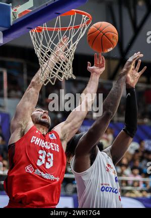 (240310) -- CEBU, 10 marzo 2024 (Xinhua) -- John Mooney (L) dei giapponesi Chiba Jets si batte per un rimbalzo contro Jameel Warney dei Seoul SK Knights della Corea del Sud durante la loro ultima partita alla East Asia Super League (EASL) Final Four 2024 nella provincia di Cebu, nelle Filippine, 10 marzo 2024. (Xinhua/Rouelle Umali) Foto Stock