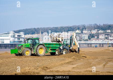 Sabbia mobile di trattori e rimorchi a Weston Super Mare Beach per combattere l'effetto della deriva a lunga costa prima della stagione estiva Foto Stock