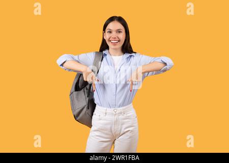 Studentessa felice con lo zaino rivolto verso il basso e sorridente Foto Stock