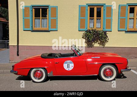 Mercedes-Benz rossa 190 SL, 1959, parcheggiata di fronte a una casa al Baiersbronn Classic 2022 Foto Stock