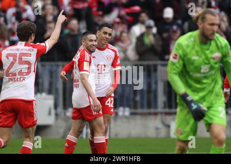 MONACO, Germania - 9. 2024 MARZO: 42 Jamal MUSIALA, 22 Raphael GUERREIRO e Thomas MUELLER celebrano durante la partita di Bundesliga tra il Bayern Muenchen e il MAINZ 05 all'Allianz Arena di Monaco il 9 MARZO. Marzo 2024 , Germania. DFL, Fussball, 8:1, (foto e copyright @ ATP Images / Arthur THILL (THILL Arthur / ATP / SPP) Foto Stock