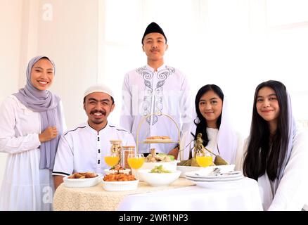 La famiglia musulmana EID Mubarak cena Iftar mangiando cibo tradizionale durante il mese di festa del Ramadan a casa. L'islamico Halal mangiare e bere ISL Foto Stock