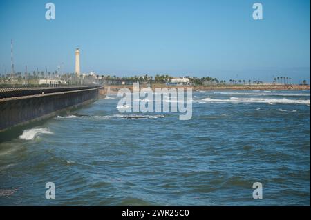 Vista delle onde del mare che colpiscono le capezzagne. faro sullo sfondo. Sullo sfondo dell'oceano Atlantico. Sfondo naturale Foto Stock