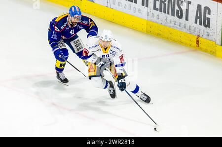 EHC Kloten - EV Zug, Stimo Arena, National League NL, stagione regolare: Stürmer #68 Fabrice Herzog (Zug) deckt den Puck gegen Verteidiger #41 Leandro Pr Foto Stock