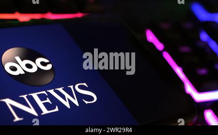 Viersen, Germania - 1 marzo. 2024: Primo piano dello smartphone con logo di ABC amercian Broadcasting News su tastiera per computer Foto Stock