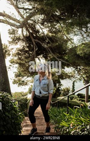 Turista femminile che si gode i Jardines de Santa Clotilde a Lloret de Mar, Spagna Foto Stock