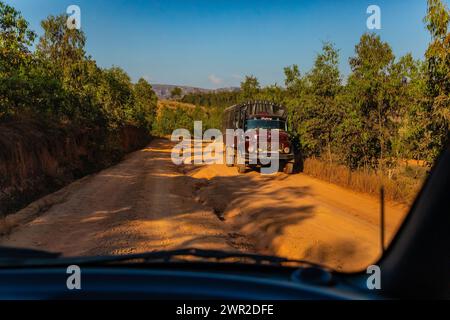 Madagascar 22. 10. 2023 .strada rossa polverosa e fangosa in cattive condizioni con grandi buchi. Le rotte sono estremamente cattive durante la stagione delle piogge in Madagascar. grande vecchio truc Foto Stock