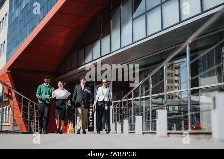 Team di persone d'affari che organizzano riunioni improvvisate all'aperto in un ambiente moderno in città in una giornata di sole Foto Stock