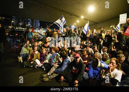 Tel Aviv, Israele. 9 marzo 2024. I manifestanti cantano mentre bloccano l'autostrada Ayalon durante la dimostrazione. Migliaia di israeliani hanno protestato contro il primo ministro Benjamin Netanyahu e il suo governo di estrema destra chiedendo il rilascio immediato degli ostaggi e le elezioni generali nello Stato di Israele. Durante la manifestazione i manifestanti hanno sfondato le barriere della polizia israeliana e sono iniziati scontri tra la polizia e i manifestanti. (Credit Image: © Matan Golan/SOPA Images via ZUMA Press Wire) SOLO PER USO EDITORIALE! Non per USO commerciale! Foto Stock