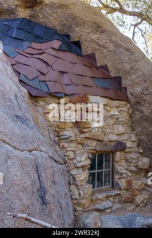 Vecchia finestra, muro di pietra e tegole metalliche al tetto della cabina della Eagle Cliff Mine al Joshua Tree National Park, California Foto Stock