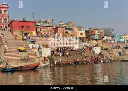 Vivace passeggiata lungo il fiume con folle ed edifici tradizionali, Varanasi, Uttar Pradesh, India Foto Stock