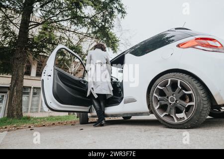 Donna d'affari sicura che esce da un'auto pronta per il lavoro Foto Stock