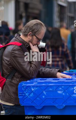 Uomo che controlla i dischi in vinile al mercato di Brick Lane Foto Stock