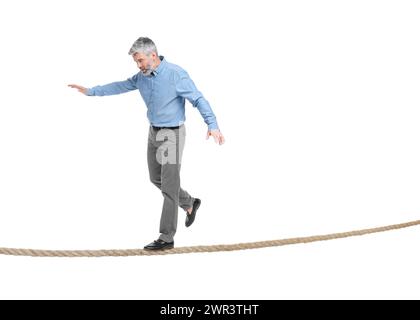 Rischi e sfide legati al possesso di un'azienda. Uomo in equilibrio sulla corda su sfondo bianco Foto Stock