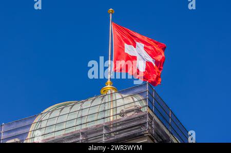 Eine Schweizer Fahne weht auf dem Bundeshaus im Wind. (Berna, Svizzera, 03.08.2023) Foto Stock