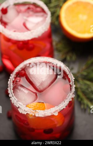 Gustoso cocktail di mirtilli con cubetti di ghiaccio in bicchieri sul tavolo, primo piano Foto Stock