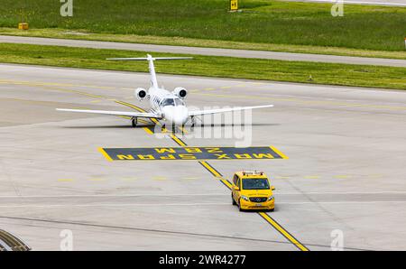 Ein Embraer Phenom 100 wird nach der Landung auf dem Flughafen Zürich von einem Bodenlotsen zum Standplatz geführt. (Zürich, Svizzera, 07.05.2023) Foto Stock