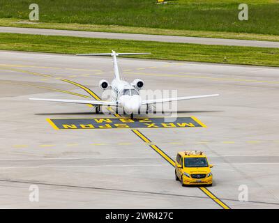 Ein Embraer Phenom 100 wird nach der Landung auf dem Flughafen Zürich von einem Bodenlotsen zum Standplatz geführt. (Zürich, Svizzera, 07.05.2023) Foto Stock