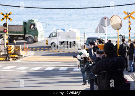 I turisti stanno scattando foto intorno all'attraversamento ferroviario alla stazione Kamakura Kokomae di Enoden nella città di Fujisawa, prefettura di Kanagawa il 28 febbraio 2024. Questo attraversamento ferroviario è presente nella famosa serie anime giapponese "Slam Dunk". E' una popolare destinazione turistica per turisti nazionali e stranieri da visitare e scattare foto. Tuttavia, a causa del gran numero di turisti in visita, il treno di Enoden è diventato estremamente affollato e i residenti che vivono lungo la linea sono stati colpiti dal problema dell'overturismo. Crediti: Yosuke Tanaka/AFLO/Alamy Live News Foto Stock