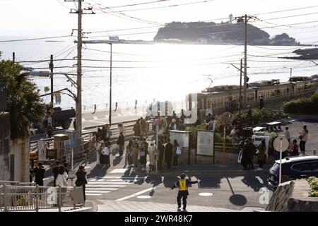 I turisti stanno scattando foto intorno all'attraversamento ferroviario alla stazione Kamakura Kokomae di Enoden nella città di Fujisawa, prefettura di Kanagawa il 28 febbraio 2024. Questo attraversamento ferroviario è presente nella famosa serie anime giapponese "Slam Dunk". E' una popolare destinazione turistica per turisti nazionali e stranieri da visitare e scattare foto. Tuttavia, a causa del gran numero di turisti in visita, il treno di Enoden è diventato estremamente affollato e i residenti che vivono lungo la linea sono stati colpiti dal problema dell'overturismo. Crediti: Yosuke Tanaka/AFLO/Alamy Live News Foto Stock