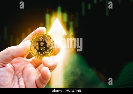 I prezzi dei Bitcoin o delle criptovalute aumentano, moneta d'oro positiva che tiene in mano con un grafico a freccia su sullo sfondo con spazio di copia, Digital crypto cur Foto Stock