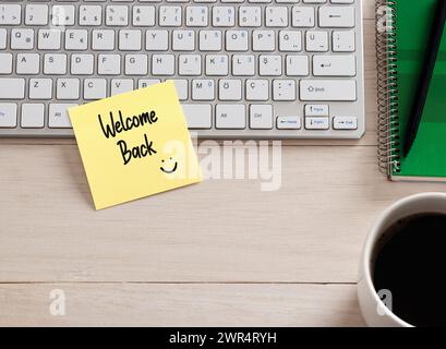 Messaggio di benvenuto scritto a mano su un foglio adesivo sulla scrivania dell'ufficio. Foto Stock