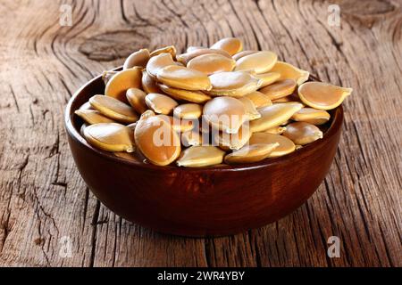 semi di zucca in un piatto su un tavolo di legno Foto Stock