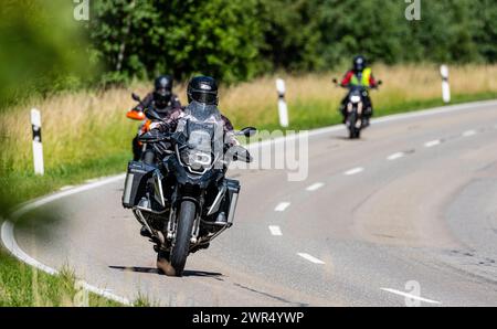 Einige Motorradfahrer fahren auf einer Überlandsstrasse ausserorts durch den Hochschwarzwald. (Bonndorf im Schwarzwald, Deutschland, 08.07.2023) Foto Stock