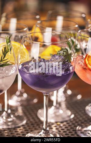 Cocktail colorati gin tonic dal gusto diverso in bicchieri da palloncino Foto Stock