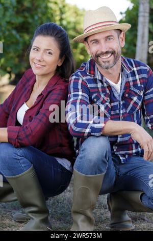 giovane coppia accovacciata nei vigneti Foto Stock