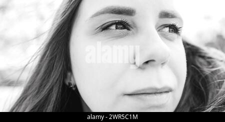 Un ritratto in bianco e nero di un volto femminile che mostra le sue caratteristiche e le sue espressioni con un contrasto sorprendente Foto Stock