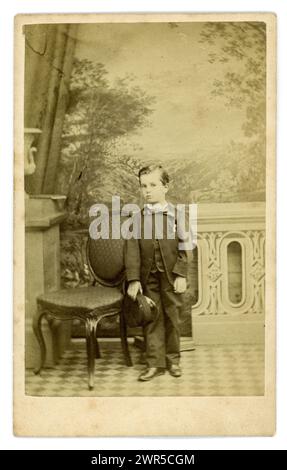 Carta de visite vittoriana originale (biglietto da visita o CDV) di giovane ragazzo vittoriano, bambino vittoriano, di circa 5 o 6 anni, con in mano un berretto, Studio of London School of Photography. Circa all'inizio degli anni '1860 Foto Stock