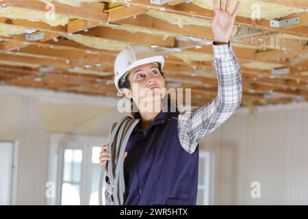 edificio femminile che controlla la capriata del tetto in legno Foto Stock