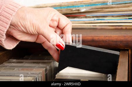 Senior che rimuove la cassetta dai vecchi mobili. Retro. Foto Stock