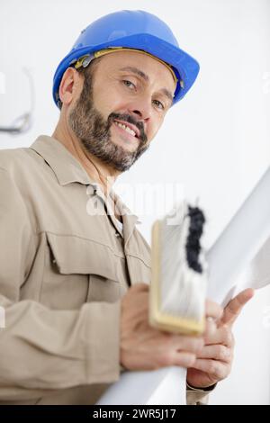 un lavoratore felice con i pennelli Foto Stock