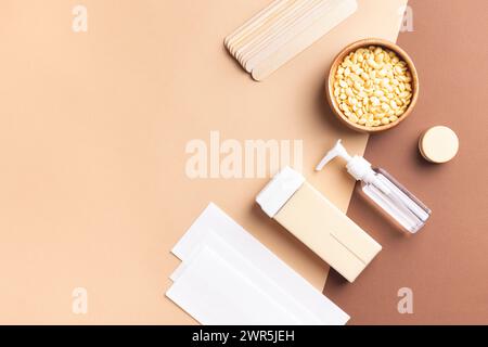 Vista dall'alto degli strumenti di depilazione su sfondo beige. Attrezzature professionali per la rimozione dei peli superflui per la pelle, la cura del corpo e la spa. Foto Stock