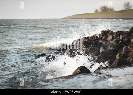 Onde tempestose lungo la costa del mare di Wadden, patrimonio dell'umanità dell'UNESCO, presso l'antico porto VOC del villaggio "Oudeschild" sull'isola di Texel, Paesi Bassi Foto Stock