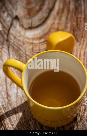 Teiera (pressa francese) con mezzo limone e teiera al tavolo di legno sul balcone, tè mattutino, aromaterapia aromatica fresca ed erboristica, tè biologico Foto Stock