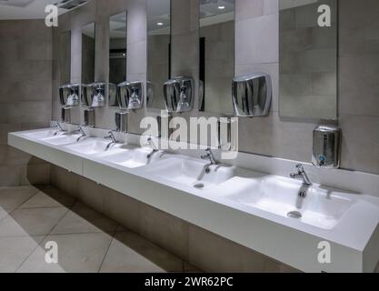 Lavabi con specchi e dispenser di sapone nella toilette pubblica alle fermate dei camion sull'autostrada italiana Foto Stock