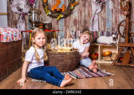 le ragazze piccole felici sono giocate con gli anatroccoli di pasqua graziosi e soffici Foto Stock