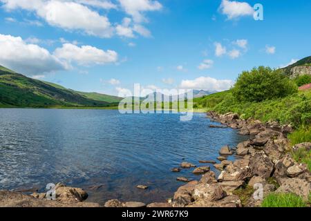 Un lago e il monte Snowdon con la catena montuosa circostante da Llynnau Mymbyr, i laghi Capel Curig nel Parco Nazionale di Snowdonia, Galles nord-occidentale, Regno Unito Foto Stock