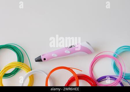 penna 3d e kit di filamento in plastica colorata su sfondo bianco con spazio di riproduzione per il testo Foto Stock