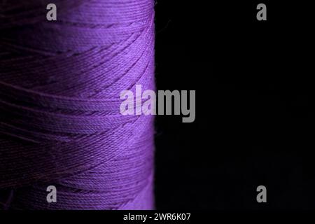 Stelo di filo viola per cucire con sfondo nero orizzontale Foto Stock